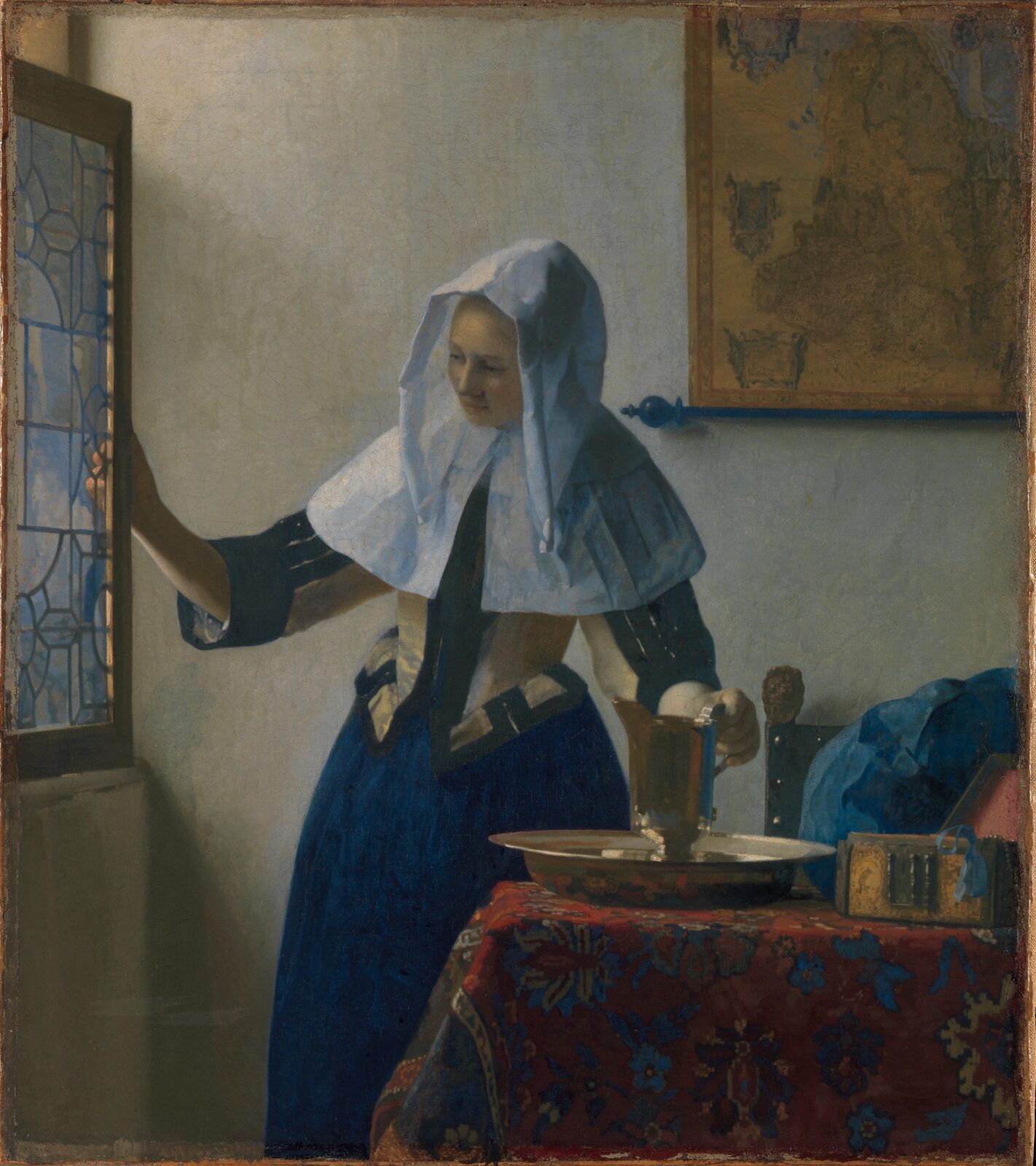 A woman in a white headscarf opening a window, her other hand on a silver pitcher